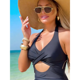 Beach Babes sexy cutout swim dress in black worn by woman with large sunhat and sunglasses at the beach