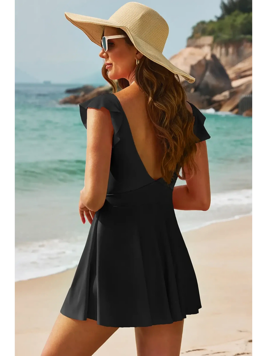 Beach Babes Swimdress Swimsuit with Coverage and Flowy Skirt in black worn by woman on beach