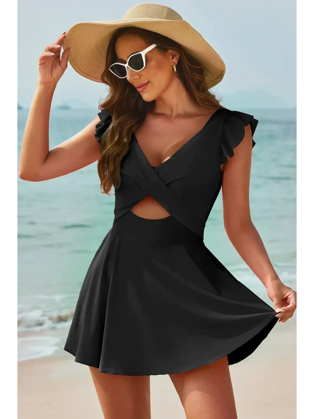Beach Babes swimdress swimsuit with coverage and flowy skirt in black worn by woman on the beach