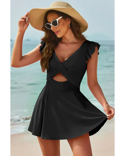 Beach Babes swimdress swimsuit with coverage and flowy skirt in black worn by woman on the beach