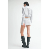 Back view of woman wearing blue and white cotton beach top with matching shorts and black boots