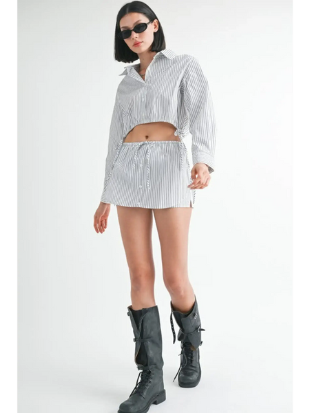 Woman wearing a blue and white cotton beach top paired with matching shorts and black boots