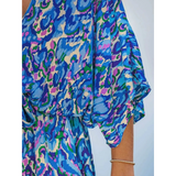 Babe Beachwaer blue batwing romper for travel with vibrant abstract print and flowing sleeve detail