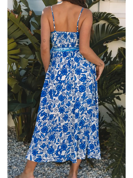 woman wearing blue floral maxi dress with a back view with spaghetti straps and fitted waist midi dress