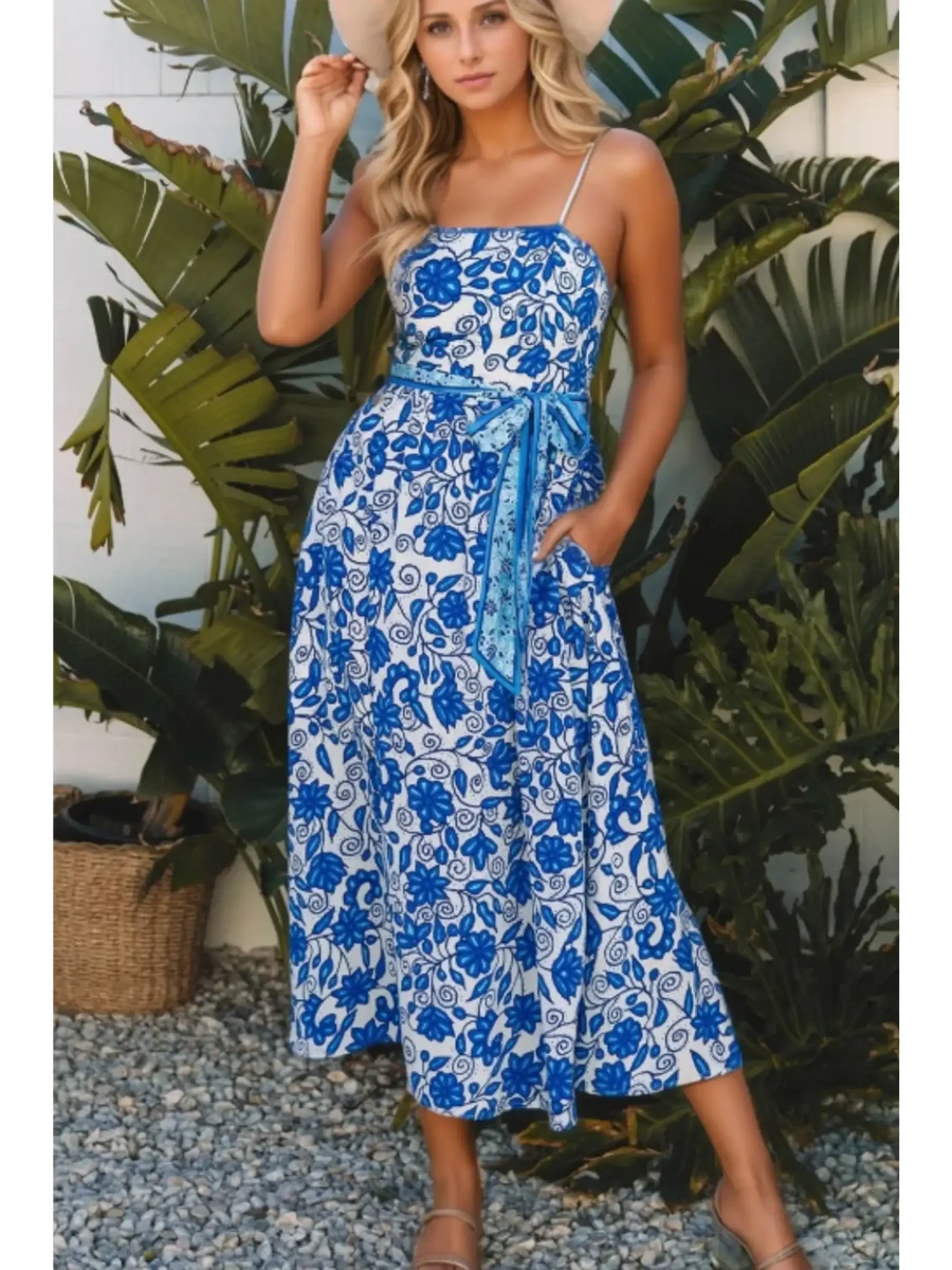 woman wearing a blue floral maxi dress affordable sleeveless midi dress with waist tie and pockets