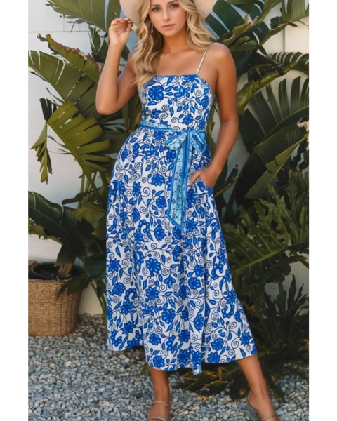 woman wearing a blue floral maxi dress affordable sleeveless midi dress with waist tie and pockets