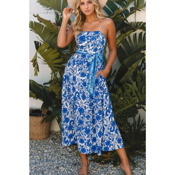 woman wearing a blue floral maxi dress affordable sleeveless midi dress with waist tie and pockets