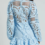 Babe Beachwear white lace mini cocktail dress with long sleeves and intricate floral patterns