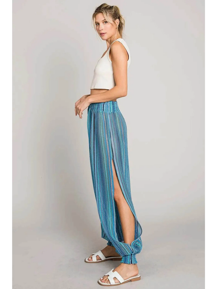 Babe Beachwear blue lightweight open leg beach pants with side slit worn by model with white tank top
