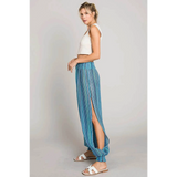 Babe Beachwear blue lightweight open leg beach pants with side slit worn by model with white tank top
