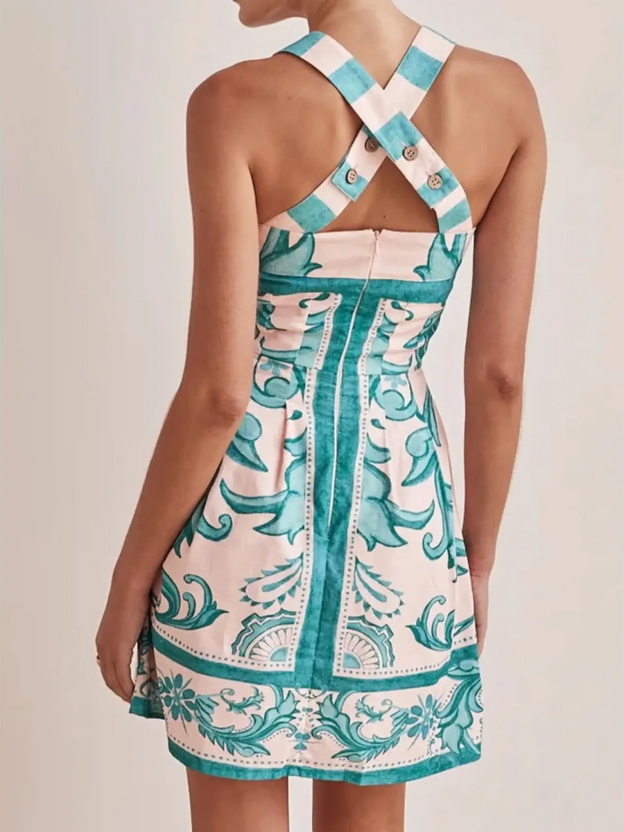 Back view of a blue mini dress by Trendsi with cross back straps and floral pattern