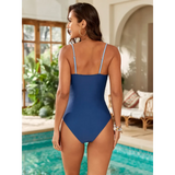Trendsi blue one piece swimsuit with cutouts shown from the back by a poolside with indoor plants