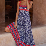 Trendsi boho beach maxi dress with red and blue patterned design worn by a woman sitting barefoot