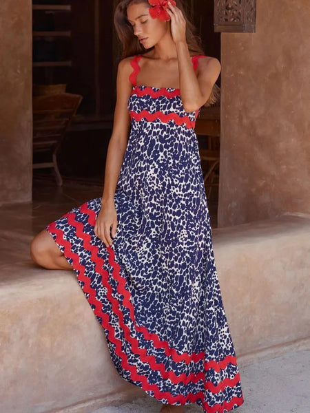 Trendsi boho beach maxi dress with red and blue patterned design worn by a woman sitting barefoot