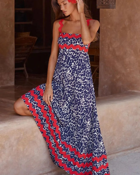 Trendsi boho beach maxi dress with red and blue patterned design worn by a woman sitting barefoot