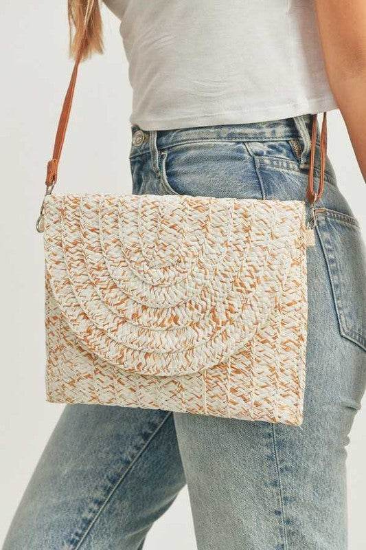 Babe Beachwear boho ivory clutch bag with woven texture and brown leather strap worn with casual jeans