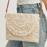 Babe Beachwear boho ivory clutch bag with woven texture and brown leather strap worn with casual jeans