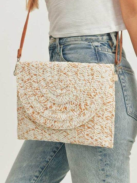 Babe Beachwear boho ivory clutch bag with woven texture and brown leather strap worn with casual jeans