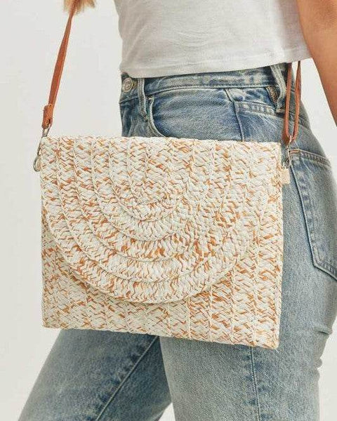 Babe Beachwear boho ivory clutch bag with woven texture and brown leather strap worn with casual jeans