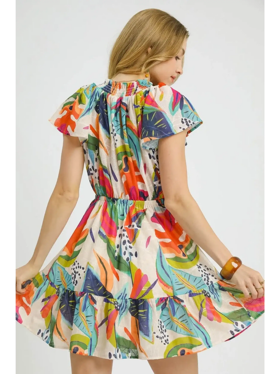Trendsi orange boho mini dress with colorful floral pattern and ruffled hem worn by woman