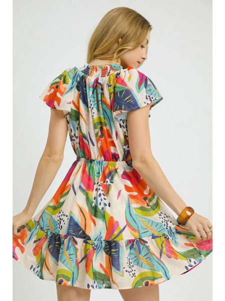 Trendsi orange boho mini dress with colorful floral pattern and ruffled hem worn by woman