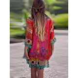 Babe Beachwear boho mini swimsuit coverup with colorful floral and geometric patterns worn by a woman