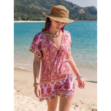 Babe Beachwear short sleeve romper with pink floral pattern worn with straw hat on the beach