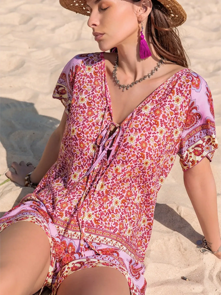 Babe Beachwear short sleeve romper with pink floral pattern worn on sand beach