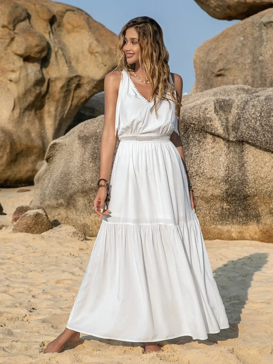 Babe Beachwear Boho summer white crochet dress maxi dress by Trendsi worn by woman on sandy beach with rocks