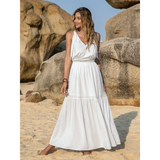 Babe Beachwear Boho summer white crochet dress maxi dress by Trendsi worn by woman on sandy beach with rocks