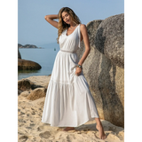 Babe Beachwearboho summer white crochet dress maxi dress worn by woman posing on beach near rocks