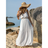 Babe Beachwear boho summer white crochet dress worn on beach with straw hat and rocky background