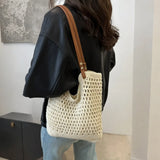 Babe Beachwear braided tote bag with leather straps worn over shoulder with black top and jeans