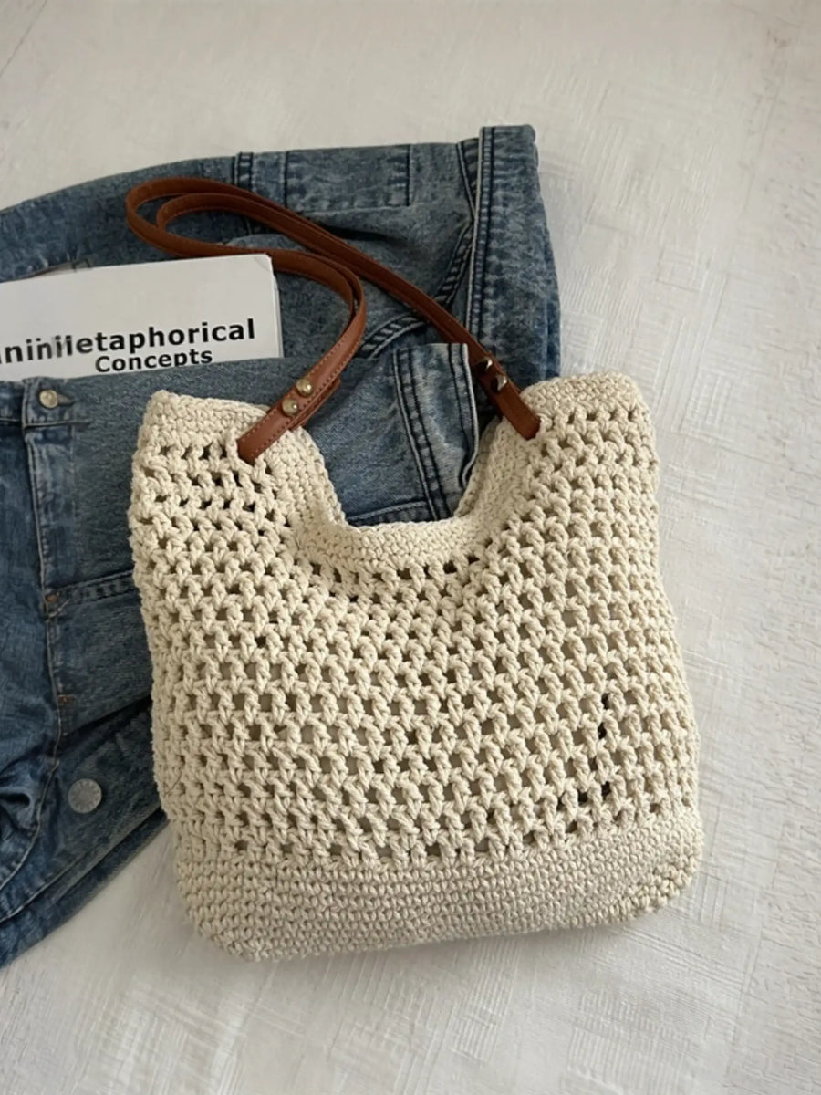 Braided tote bag with leather straps by Babe Beachwear placed on denim jeans and white surface