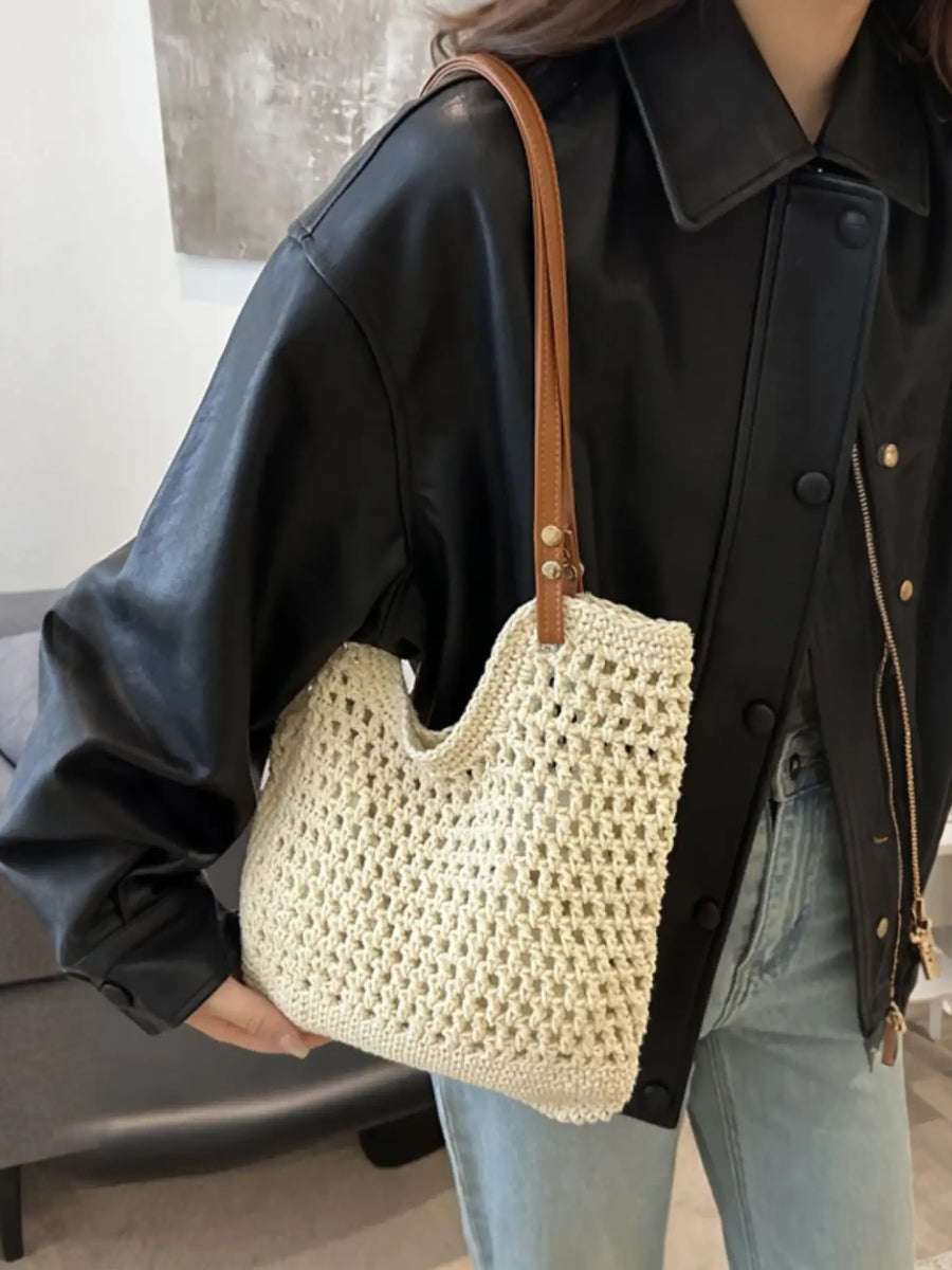 Babe Beachwear braided tote bag with leather straps carried by a woman wearing a black jacket and jeans