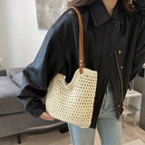 Babe Beachwear braided tote bag with leather straps carried by a woman wearing a black jacket and jeans