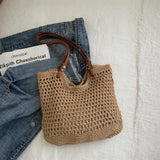 Babe Beachwaer braided tote bag with leather straps placed on denim jacket and white surface