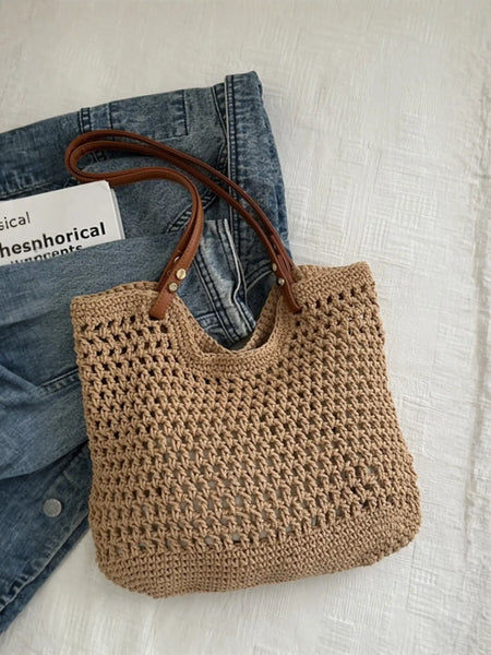 Babe Beachwaer braided tote bag with leather straps placed on denim jacket and white surface
