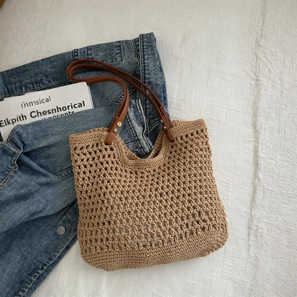 Babe Beachwaer braided tote bag with leather straps placed on denim jacket and white surface