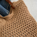 Close-up of a Babe Beachwear braided tote bag with leather straps showing detailed woven texture