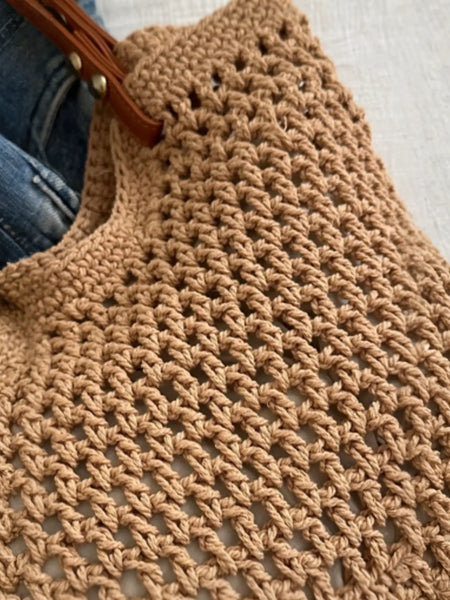 Close-up of a Babe Beachwear braided tote bag with leather straps showing detailed woven texture
