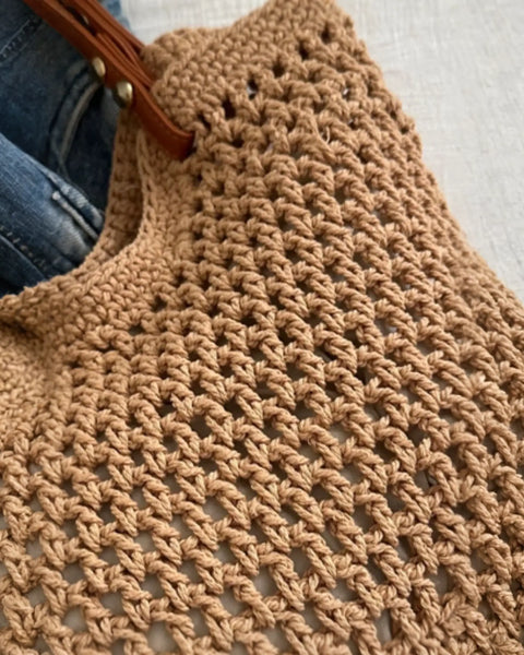 Close-up of a Babe Beachwear braided tote bag with leather straps showing detailed woven texture