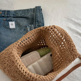 Babe Beachwear braided tote bag with leather straps showing interior with wallet and phone inside