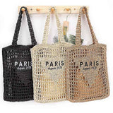 Three Paris Crochet Straw Summer Tote bags in black, beige, and brown hanging on wooden hooks
