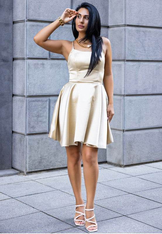 Woman wearing nude block heel summer sandals paired with a light beige sleeveless dress outdoors