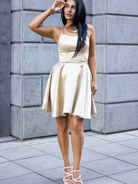 Woman wearing nude block heel summer sandals paired with a light beige sleeveless dress outdoors