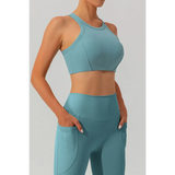 Women's racerback active tank in teal blue by Babe Beachwear modeled with matching high-waist leggings