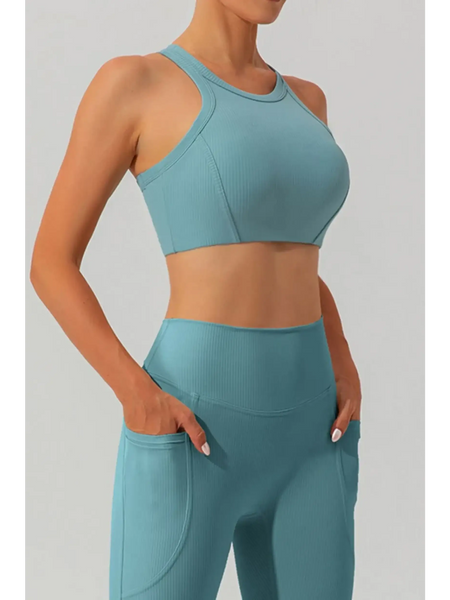 Women's racerback active tank in teal blue by Babe Beachwear modeled with matching high-waist leggings