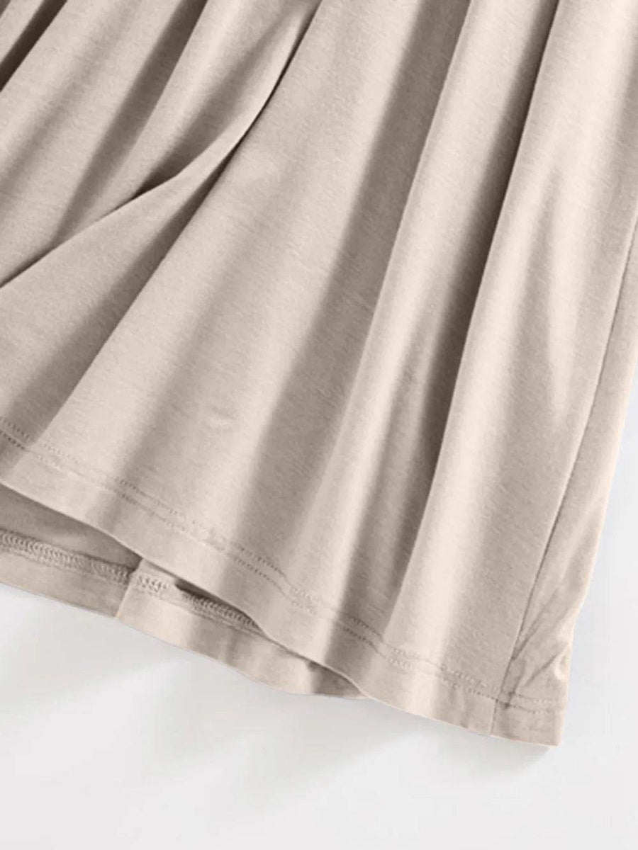 Close-up of beige fabric showing soft texture of the Built-In Bra Shelf Midi Dress by Trendsi