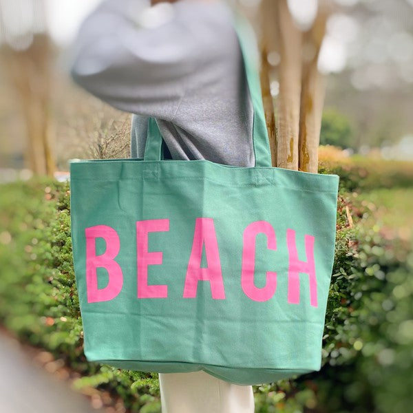 Babe Beachwear Canvas Beach Tote in mint green with pink BEACH lettering carried on shoulder